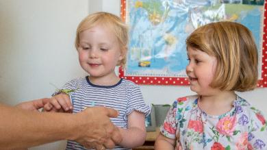 
		zwei kleine Mädchen mit Heuschrecke auf der Hand
	