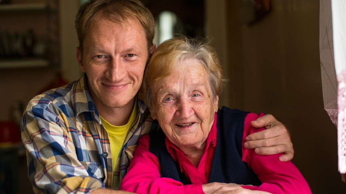 Alte Frau mit Sohn umarmen sich