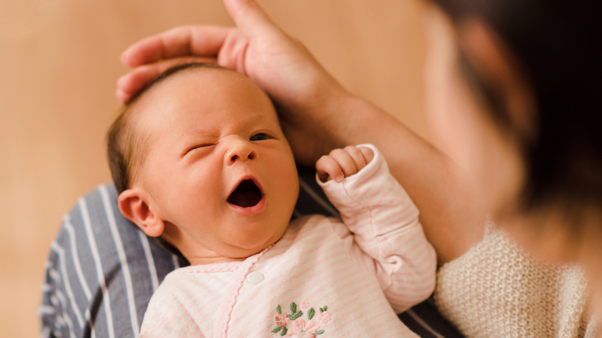 Mutter mit gähnendem Baby