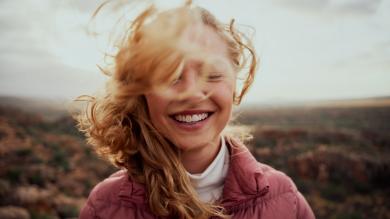 
		Eine junge Frau im Porträt lächelt optimistisch
	