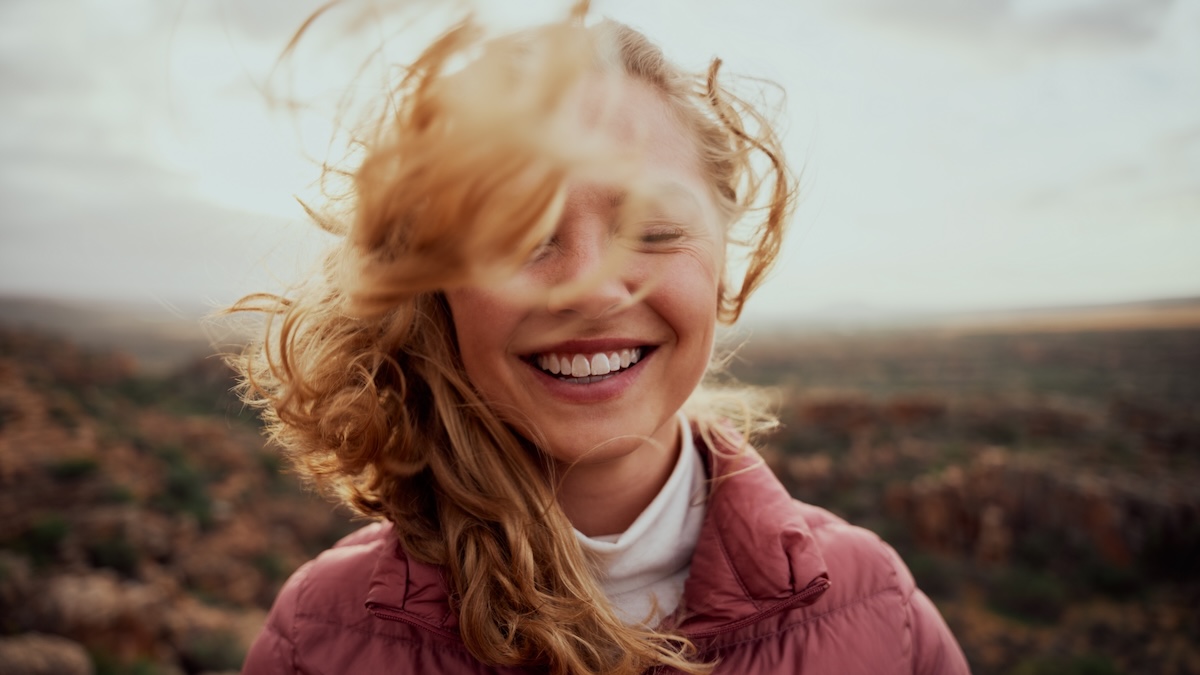 Eine junge Frau im Porträt lächelt optimistisch